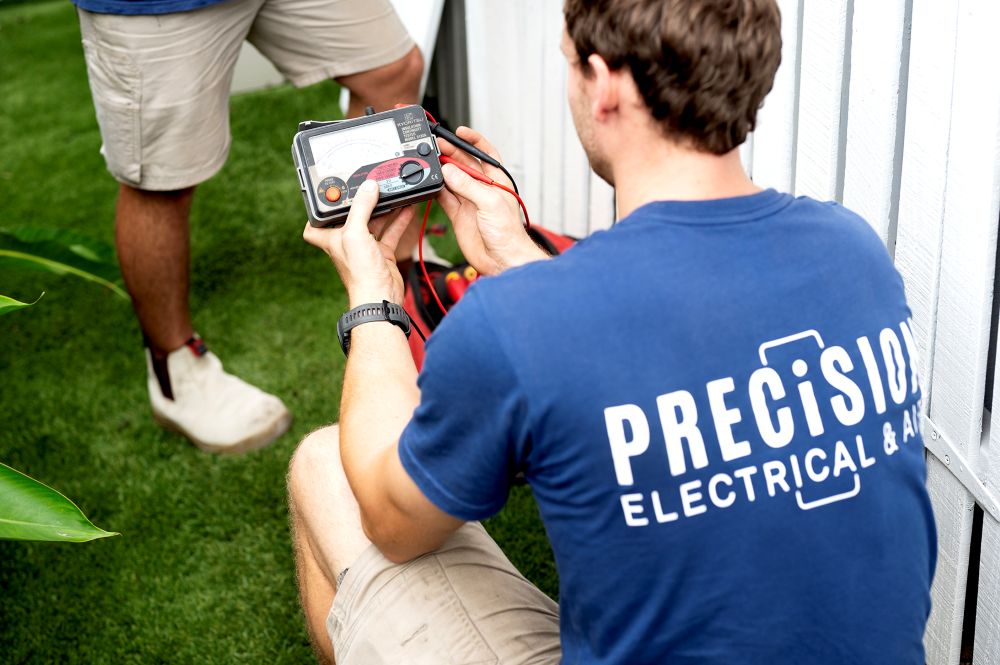 Precision Electrical & Air electrician working on an outdoor electrical installation