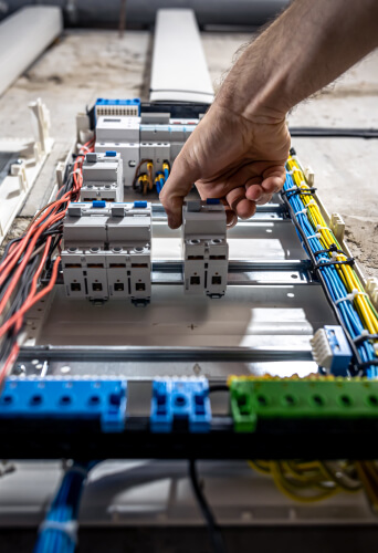 Electrician working inside a switchboard